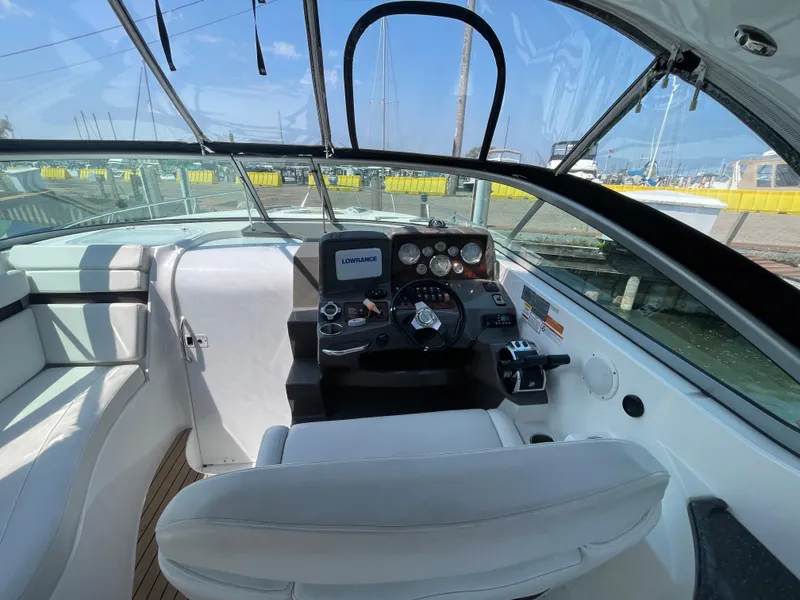 Slide: The Image of 2013 Rinker 310 Express Cruiser cockpit with steering wheel and navigation system. - 16
