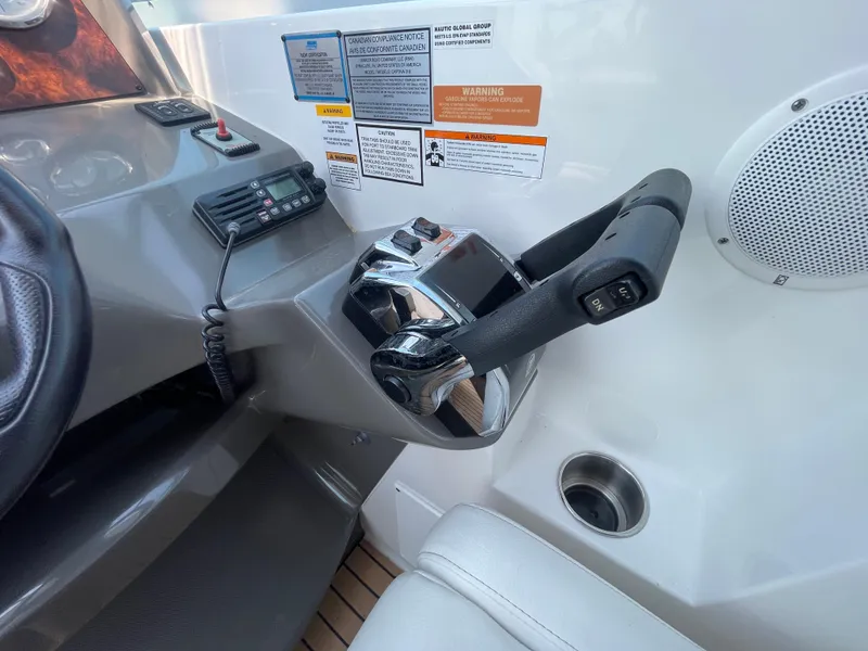 Slide: The Image of 2013 Rinker 310 Express Cruiser helm with controls and warning labels. - 22
