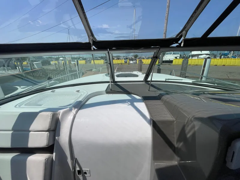 Slide: The Image of 2013 Rinker 310 Express Cruiser cockpit view with clear skies and marina background. - 24