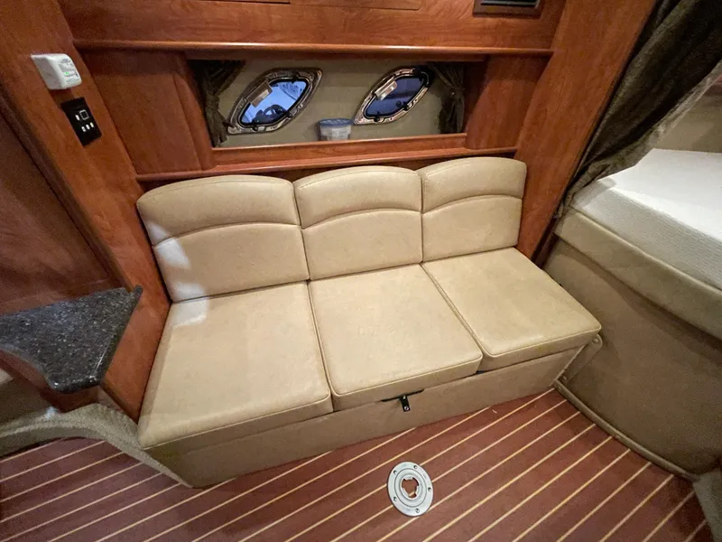 Slide: The Image of Interior of 2013 Rinker 310 Express Cruiser with beige seating and wooden accents. - 26