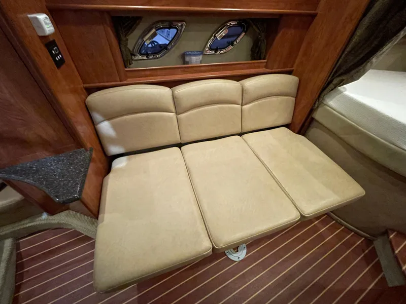 Slide: The Image of 2013 Rinker 310 Express Cruiser interior with beige seating and wooden accents. - 27