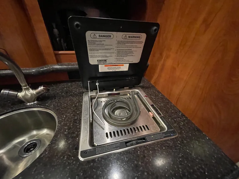 Slide: The Image of 2013 Rinker 310 Express Cruiser kitchen with stove and sink. - 31