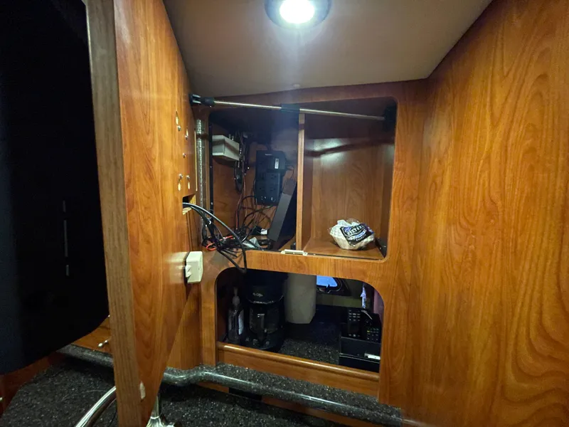 Slide: The Image of Interior of 2013 Rinker 310 Express Cruiser with wooden cabinetry and storage space. - 32