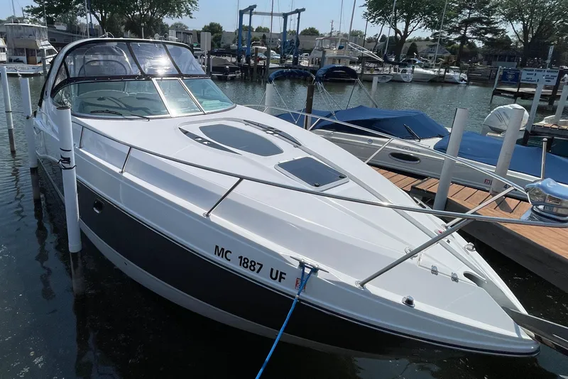 Slide: The Image of 2013 Rinker 310 Express Cruiser docked at marina, sleek design, sunny day. - 4