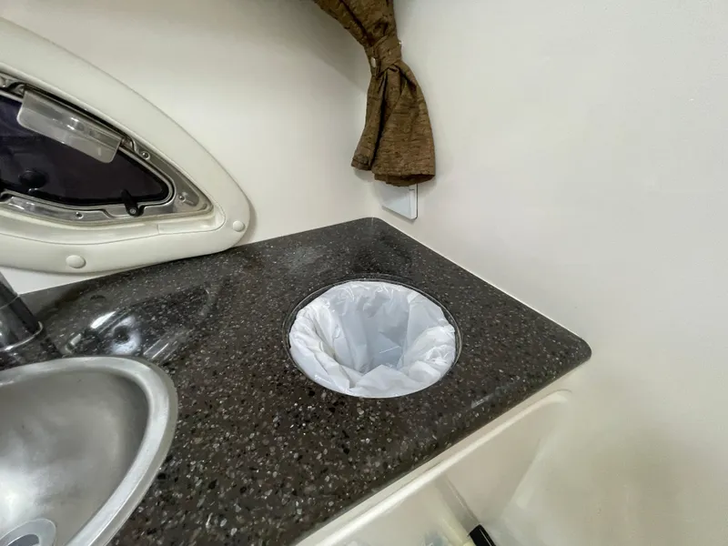 Slide: The Image of 2013 Rinker 310 Express Cruiser interior with sink and countertop waste bin. - 42