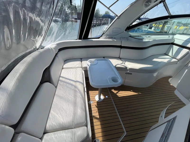 Slide: The Image of 2013 Rinker 310 Express Cruiser interior with white seating and wooden flooring. - 9