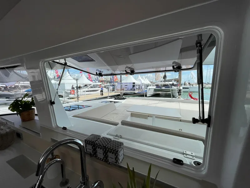 Slide: The Image of View from Bali 4.4 yacht window, showcasing marina and docked boats, 2026 model. - 16
