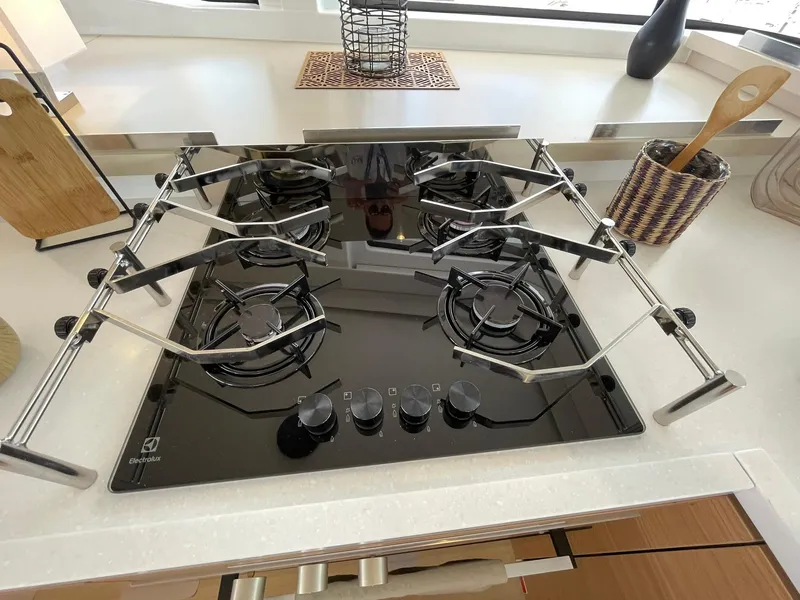 Slide: The Image of Modern Bali 4.4 gas stove, 2026 model, with four burners and sleek black design in a kitchen setting. - 17