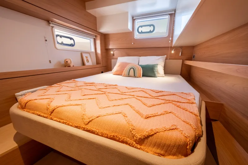 Slide: The Image of Cozy bedroom in 2026 Bali 4.4 yacht with orange blanket and decorative pillows. - 22