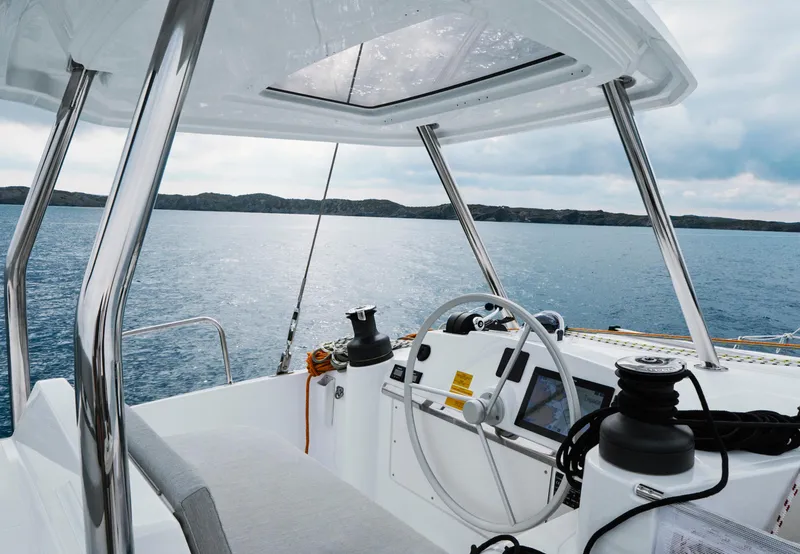 Slide: The Image of Modern Bali 4.4 yacht cockpit with steering wheel, overlooking serene ocean and distant horizon, 2026 model. - 25
