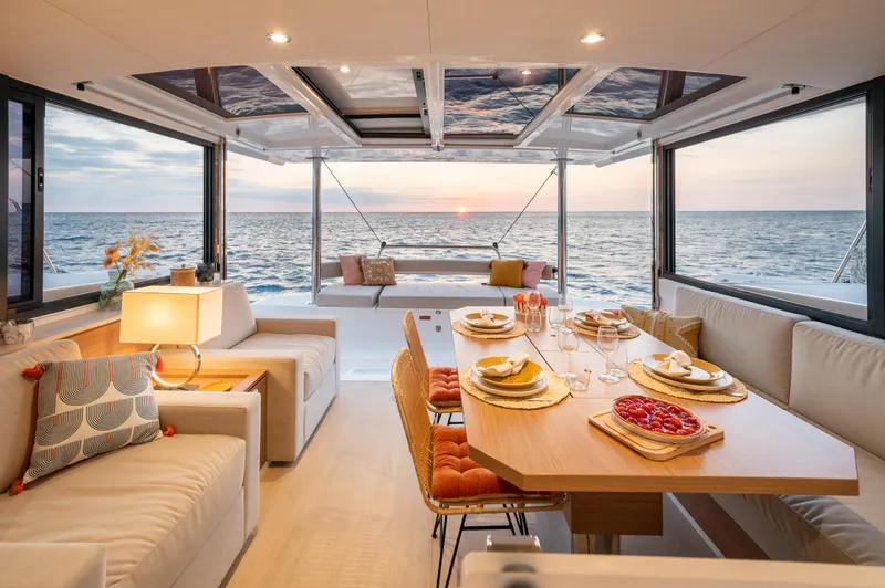 Slide: The Image of Luxurious Bali 4.4 yacht interior with elegant dining setup and ocean sunset view, 2026 model. - 3