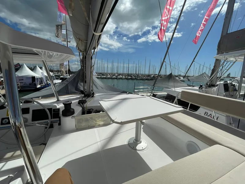 Slide: The Image of Modern Bali 4.4 yacht interior with seating and table, docked at marina under blue sky. - 30