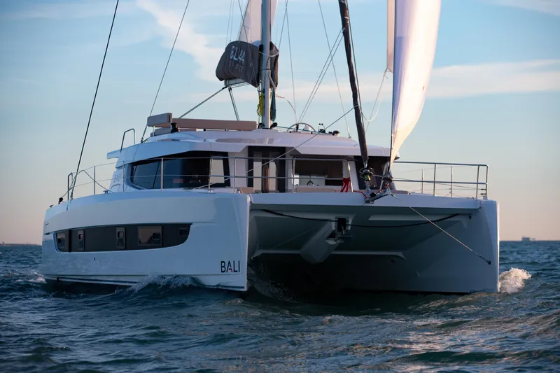Slide: The Image of Modern Bali 4.4 catamaran sailing on open sea, 2026 model, under clear blue sky. - 31