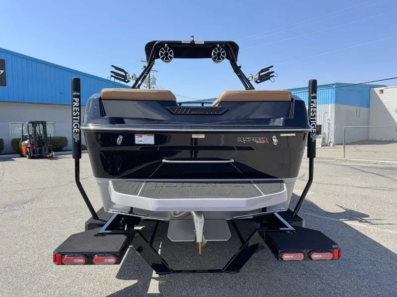 Slide: The Image of 2025 Moomba Tykon boat rear view, parked on trailer in industrial area. - 10