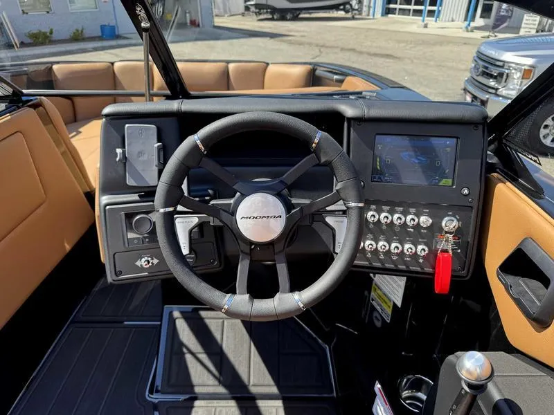 Slide: The Image of 2025 Moomba Tykon boat dashboard with steering wheel, touchscreen, and control panel. - 4