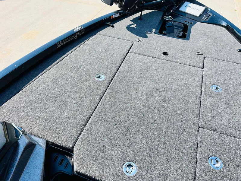 Slide: The Image of 2025 Ranger Z518 Cup-Equipped boat deck with gray carpet and storage compartments. - 16