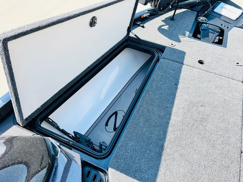 Slide: The Image of Open storage compartment in 2025 Ranger Z518 Cup-Equipped boat, featuring carpeted interior. - 17
