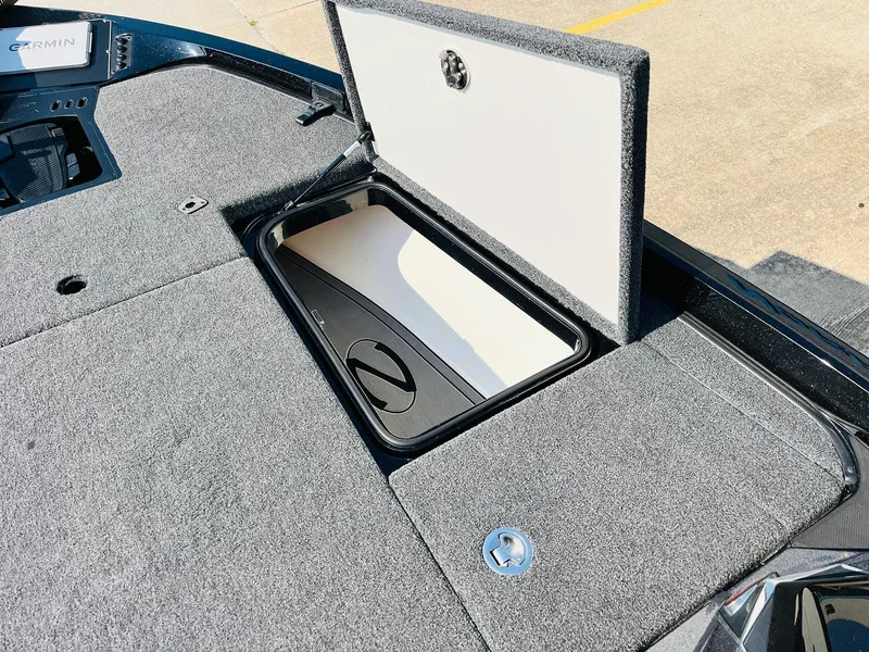 Slide: The Image of 2025 Ranger Z518 Cup-Equipped boat storage compartment with open lid, featuring carpeted surface. - 23