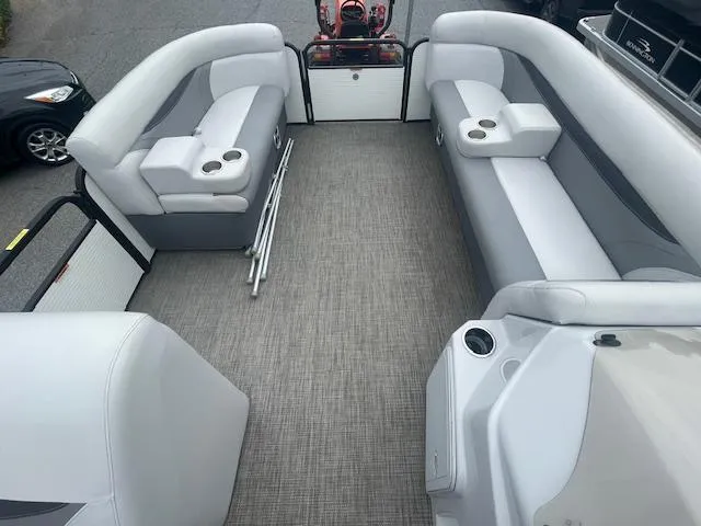Slide: The Image of 2016 Sweetwater 2286 pontoon boat interior with gray seating and cup holders. - 12
