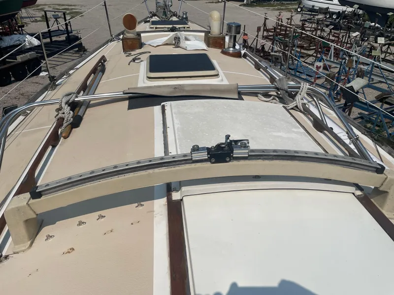 Slide: The Image of 1980 Cape Dory 36 sailboat deck with rigging and hatch, docked in a boatyard. - 12