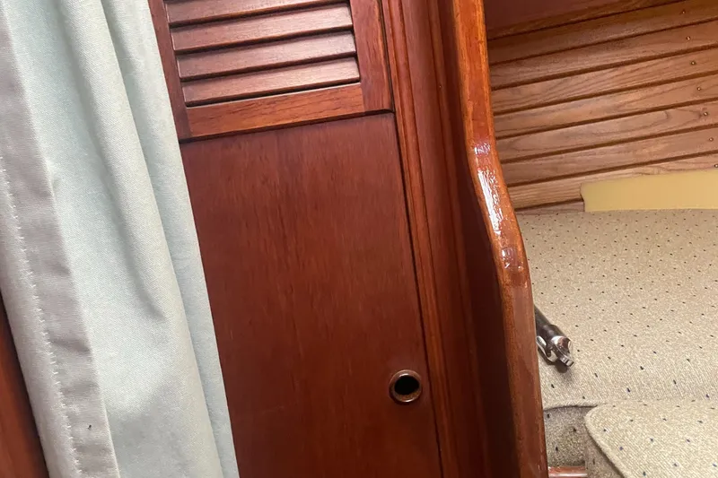 Slide: The Image of Interior of 1980 Cape Dory 36 sailboat with wooden paneling and fabric curtain. - 18