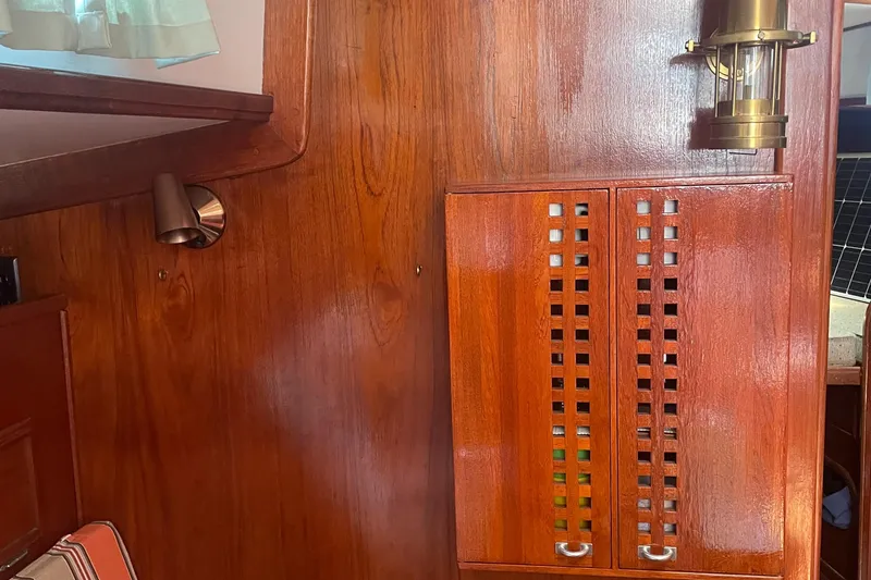 Slide: The Image of Interior of 1980 Cape Dory 36 sailboat with wooden cabinetry and brass lighting fixture. - 22