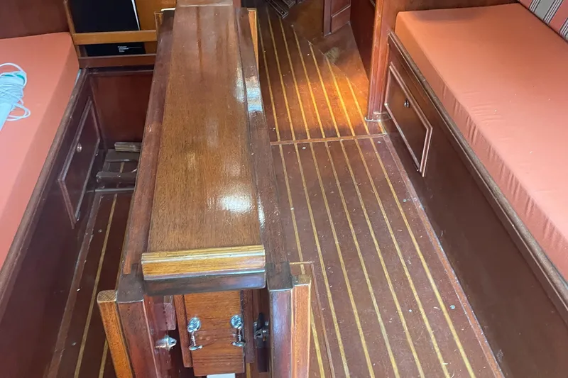 Slide: The Image of Interior of 1980 Cape Dory 36 sailboat with wooden flooring and cushioned seating. - 25