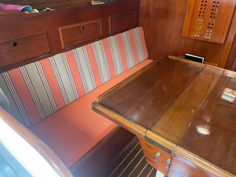 Slide: The Image of Interior of 1980 Cape Dory 36 sailboat with striped seating and wooden table. - 26