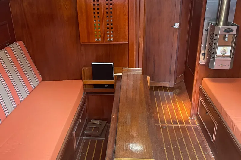 Slide: The Image of Interior of 1980 Cape Dory 36 sailboat with wood paneling and orange cushions. - 31