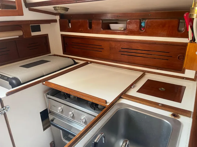Slide: The Image of 1980 Cape Dory 36 yacht kitchen with stove, sink, and wooden cabinetry. - 34