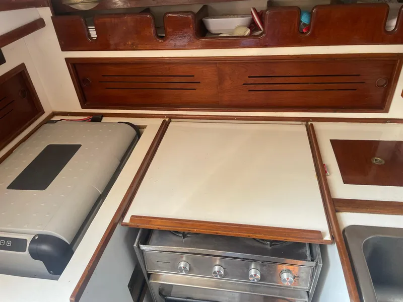 Slide: The Image of Galley kitchen of 1980 Cape Dory 36 sailboat with stove and wooden cabinetry. - 37
