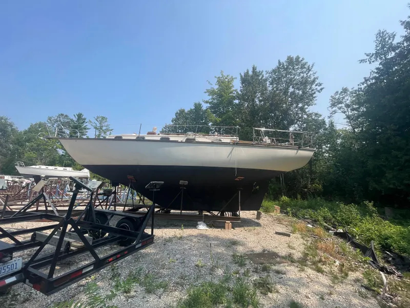 Slide: The Image of 1980 Cape Dory 36 sailboat on trailer, surrounded by trees and clear sky. - 4