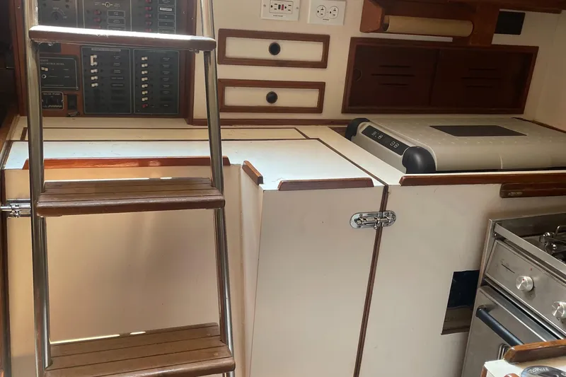 Slide: The Image of Interior of a 1980 Cape Dory 36 sailboat featuring a compact kitchen and ladder. - 42