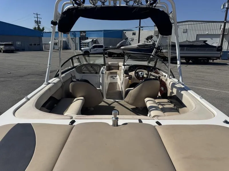 Slide: The Image of 2002 Tigé 2300V Limited boat interior with seating and steering wheel, parked in a marina. - 13