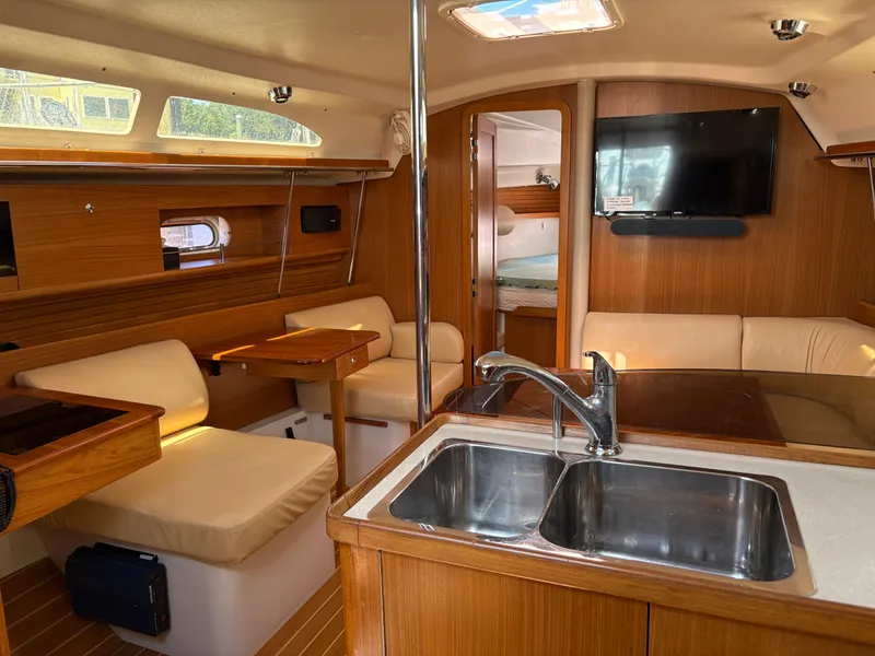Slide: The Image of Interior of 2011 Catalina 355 sailboat with modern kitchen and cozy seating area. - 27