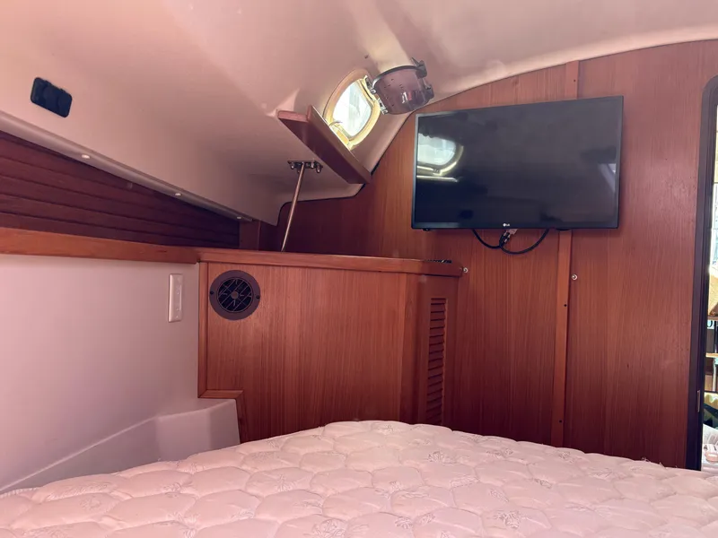 Slide: The Image of Interior of 2011 Catalina 355 yacht cabin with TV and wooden paneling. - 33