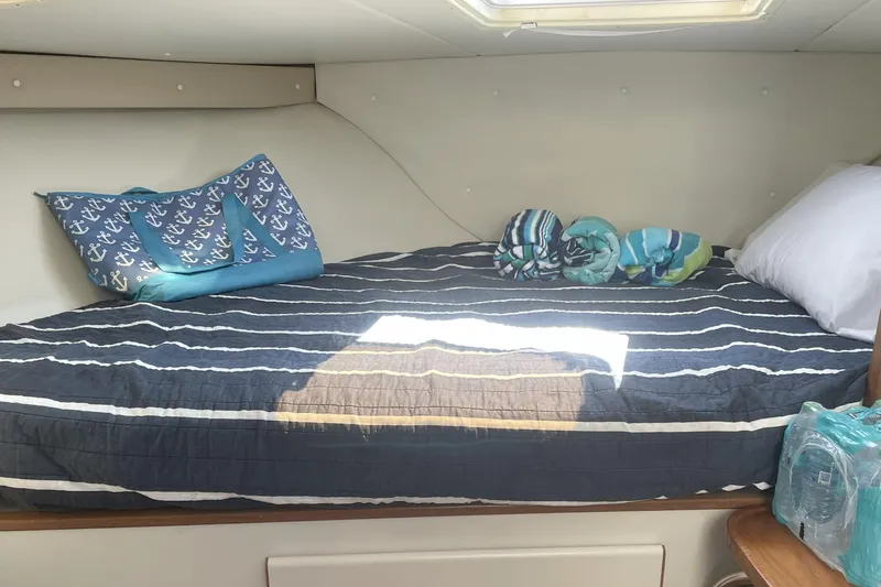 Slide: The Image of Cozy cabin bed in 1996 Pursuit Offshore boat with nautical-themed decor. - 4