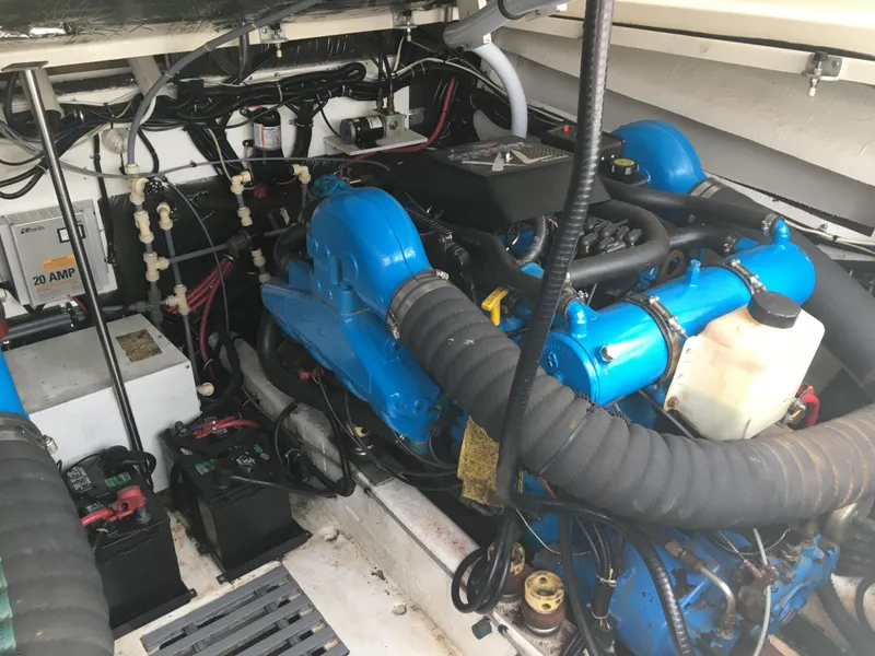 Slide: The Image of Engine room of a 1996 Pursuit Offshore boat, featuring blue engine components and wiring. - 8