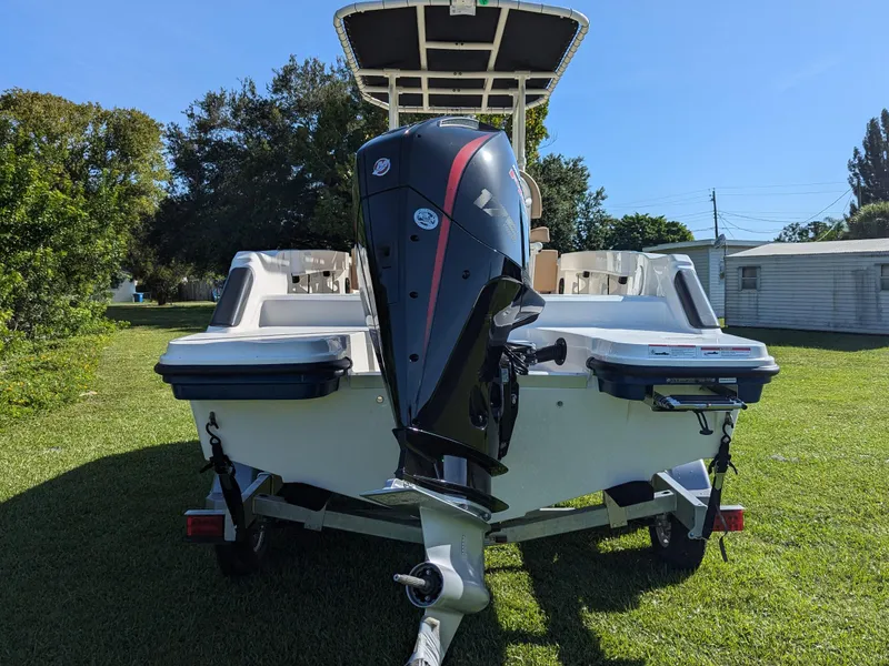 Slide: The Image of 2025 Bayliner Trophy T20CC boat with outboard motor on trailer, parked on grass. - 14