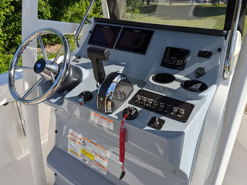 Slide: The Image of 2025 Bayliner Trophy T20CC boat console with steering wheel, controls, and navigation displays. - 21