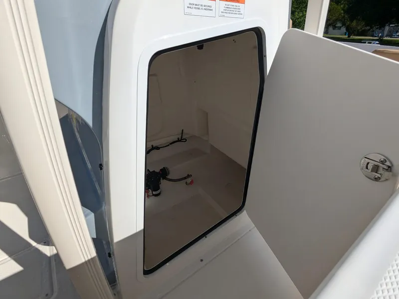Slide: The Image of 2025 Bayliner Trophy T20CC storage compartment with open door, showcasing interior space. - 25
