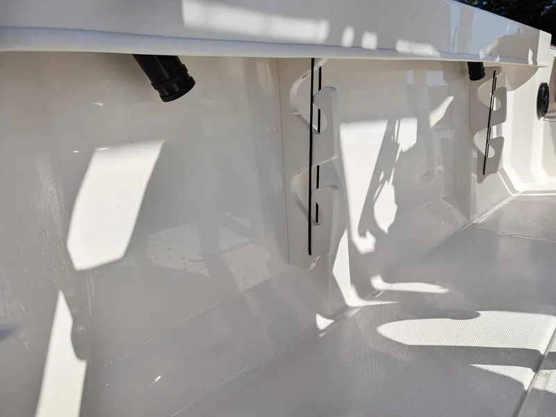 Slide: The Image of 2025 Bayliner Trophy T20CC interior detail with rod holders and sleek white finish. - 26
