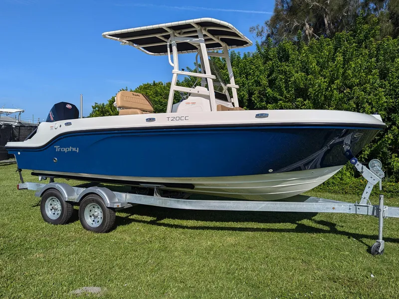 The Image of 2025 Bayliner Trophy T20CC boat on trailer, blue hull, parked on grass. - 8