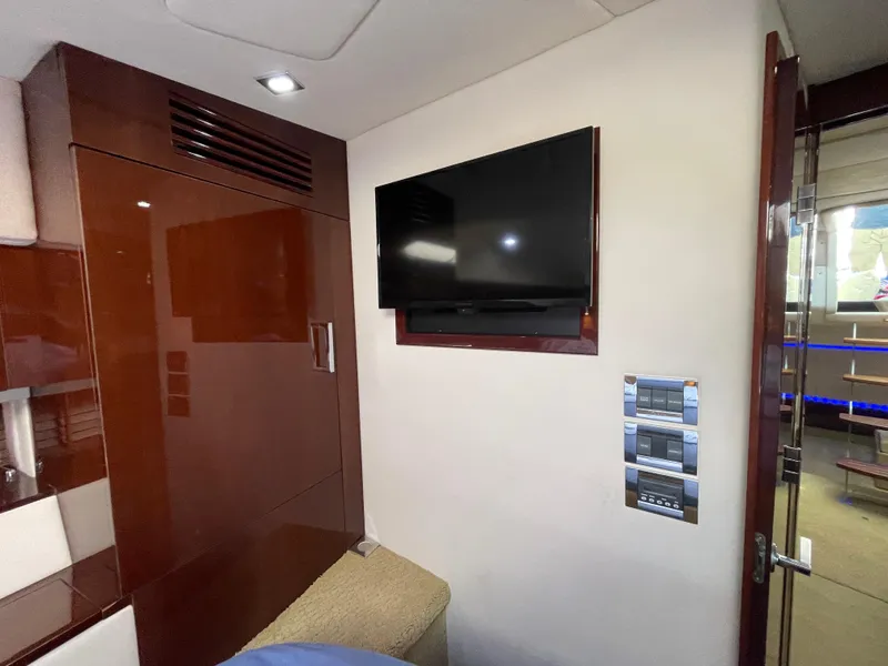 Slide: The Image of Interior of 2010 Sea Ray 450 Sundancer with wall-mounted TV and control panels. - 21