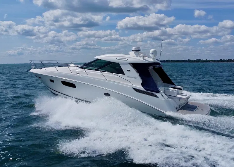 Slide: The Image of 2010 Sea Ray 450 Sundancer yacht cruising on open water under a blue sky. - 3