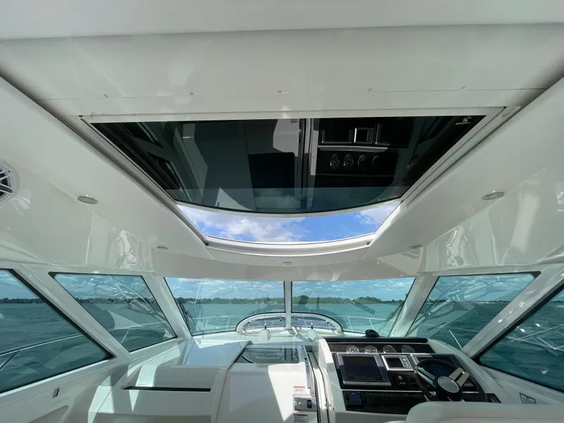 Slide: The Image of Interior view of 2010 Sea Ray 450 Sundancer yacht with open sunroof and modern dashboard. - 41