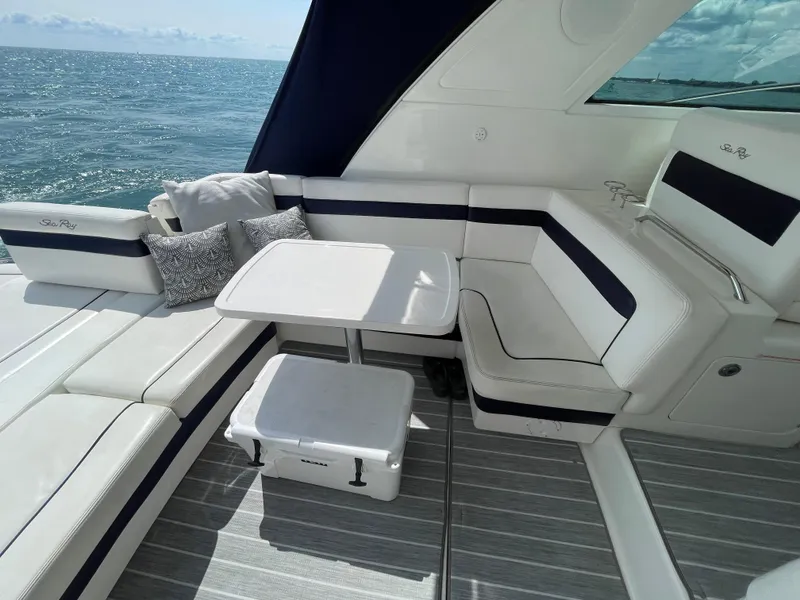 Slide: The Image of 2010 Sea Ray 450 Sundancer yacht interior with cushioned seating and table, ocean view. - 42