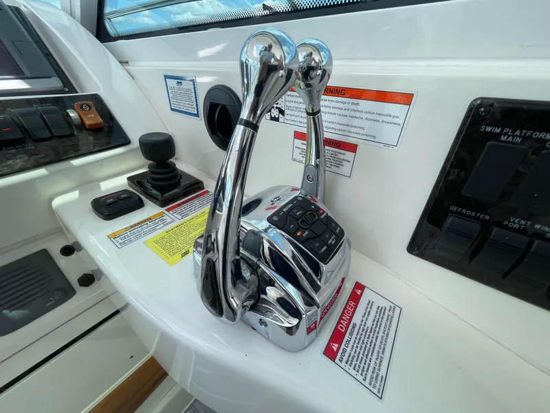Slide: The Image of Control panel of a 2010 Sea Ray 450 Sundancer boat with throttle levers and warning labels. - 48