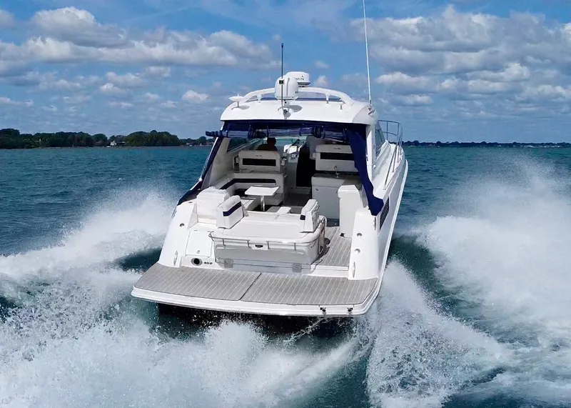 Slide: The Image of 2010 Sea Ray 450 Sundancer cruising on open water under a partly cloudy sky. - 9