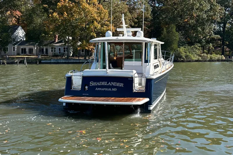 Slide: The Image of 2022 Sabre 45 Salon Express cruising on a scenic lake with lush green forest backdrop. - 4